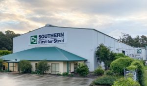 Exterior view of a big warehouse of Southern Steel with plants outside